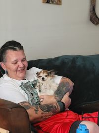 Young woman with dog on sofa at home