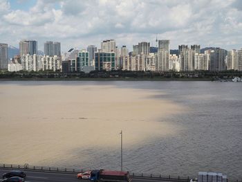 Scenic view of sea by buildings against sky