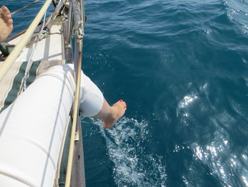 Low section of person sailing on sailboat in sea