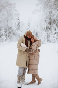 Rear view of girl standing on snow covered field