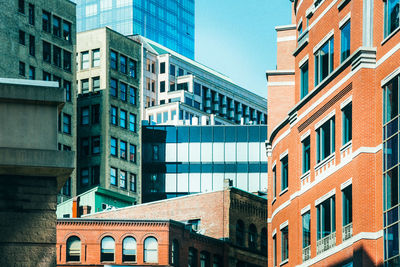 Low angle view of modern buildings against clear blue sky