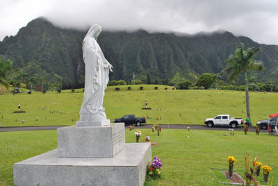 Statue on field against sky