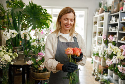 Portrait of young woman standing against plants