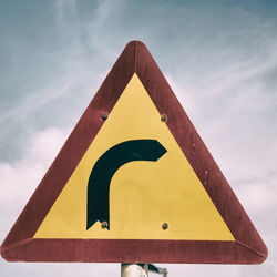 Low angle view of road sign against sky