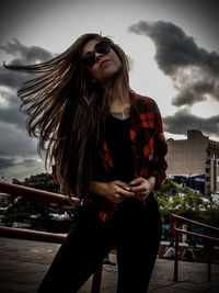 Young woman wearing sunglasses against sky