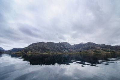 Scenic view of lake by mountain against sky