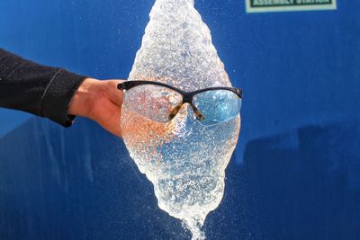 Close-up of human hand holding blue sea