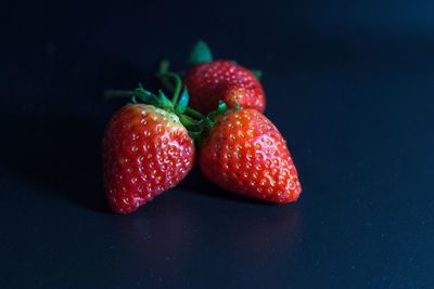 Close-up of strawberries on table against black background