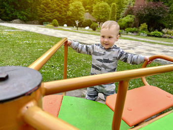 Happy toddler boy on a swing 