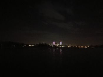 Illuminated cityscape against sky at night