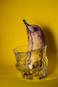 Close-up of drink in bowl against yellow background