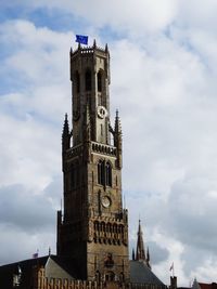 Low angle view of clock tower against cloudy sky