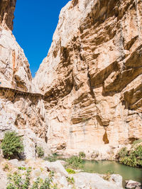 Rock formations by mountains against sky