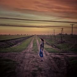 Rear view of man walking on dirt road