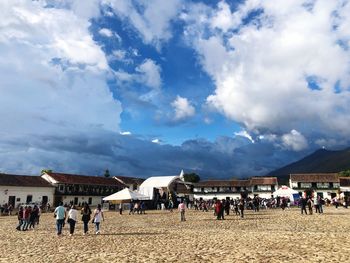 People at town square against cloudy sky