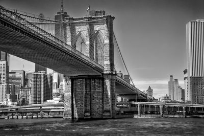 Low angle view of brooklyn bridge over east river in city