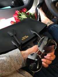 High angle view of man holding camera while sitting in car