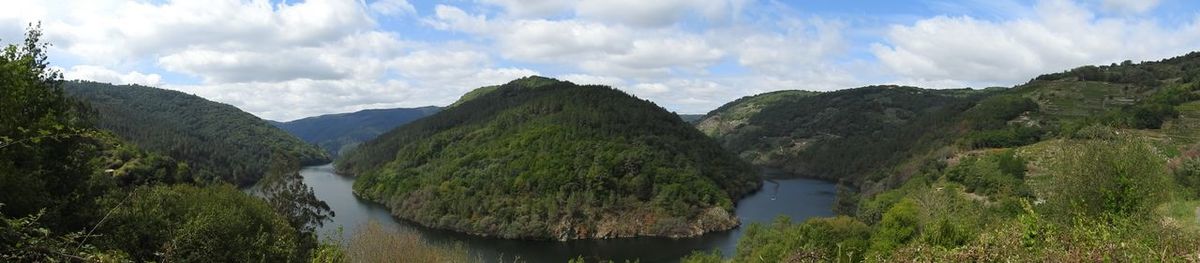 Panoramic view of river amidst mountains against sky