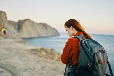 Woman standing at beach against sky