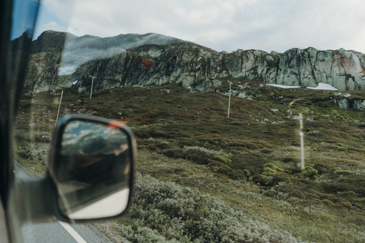 REFLECTION OF MOUNTAINS IN CAR MIRROR