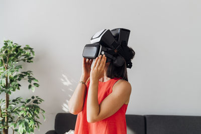 Woman wearing virtual reality simulator at home