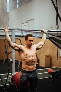 Shirtless man exercising in gym