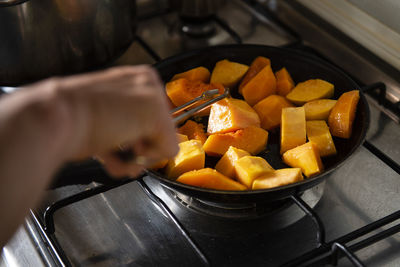 Woman cooking a vegetable soup with pumpkin, potato and onion. c