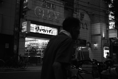 Man walking on street in city at night