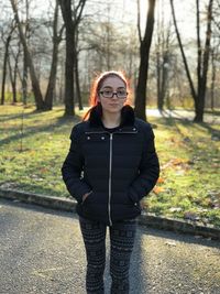 Portrait of young woman standing in park during autumn