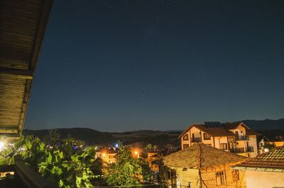 Illuminated town against sky at night