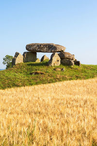 Old ruin on field against clear blue sky