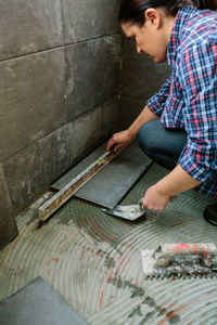High angle view of man working on floor against wall