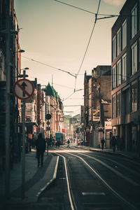 City street and buildings against sky at sunset
