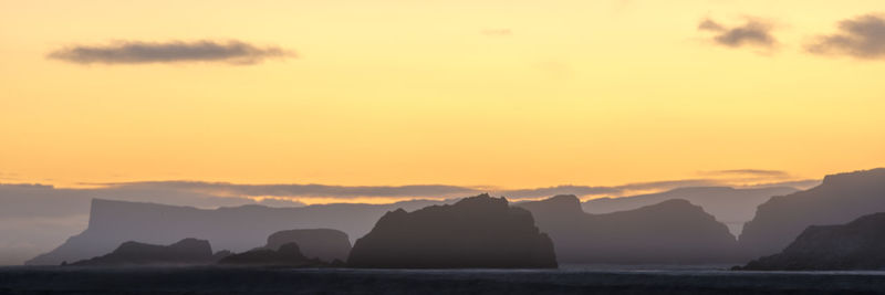 Scenic view of silhouette mountains against sky during sunset