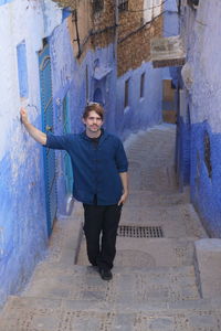 Portrait of young man standing in alley