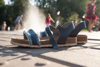 Close-up of shoes in park on sunny day