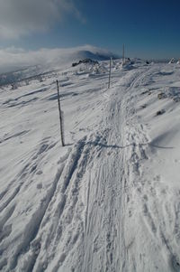 Scenic view of snow covered land against sky