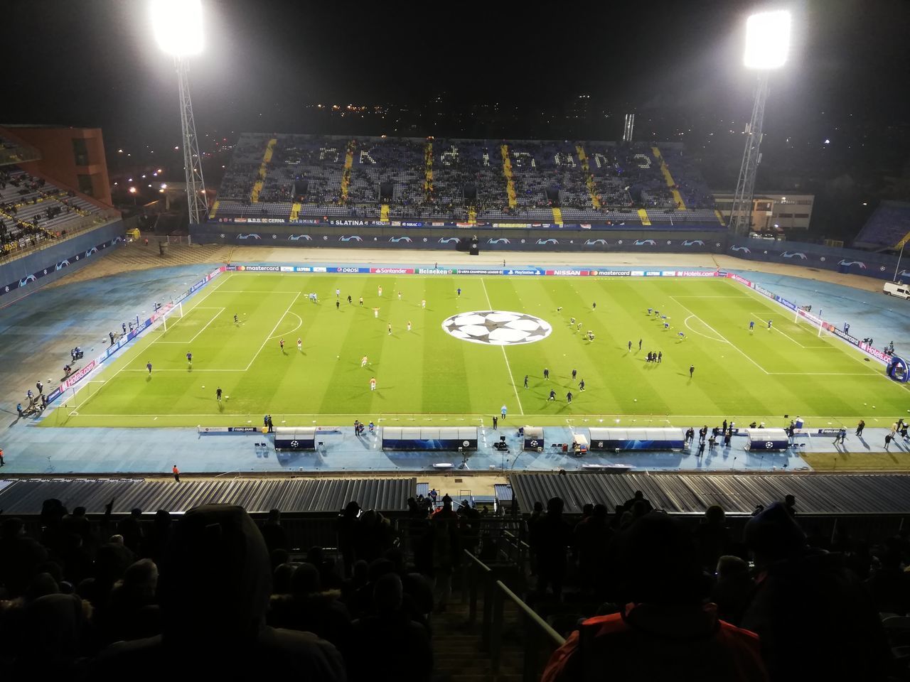 HIGH ANGLE VIEW OF PEOPLE ON SOCCER FIELD AT NIGHT