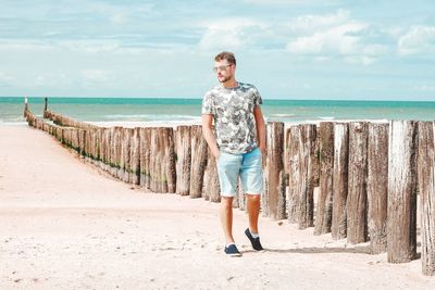 Full length of man walking at beach during sunny day