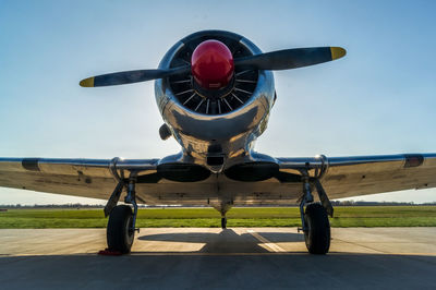 Old-fashioned airplane on runway against clear sky