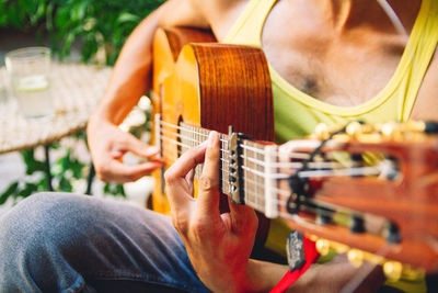 Midsection of man playing guitar