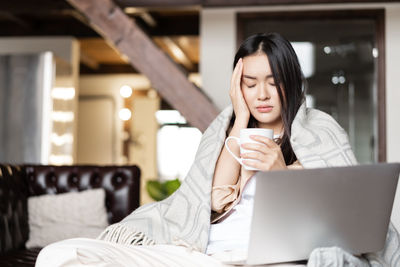 Young woman using laptop at home