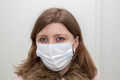 Young woman with protective face mask against white back ground