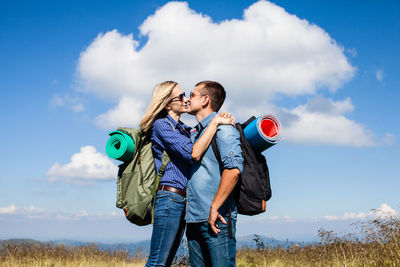 Couple standing on field against sky