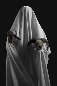 View of white holding rose against black background