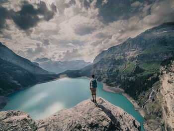Rear view of man looking at mountains against sky