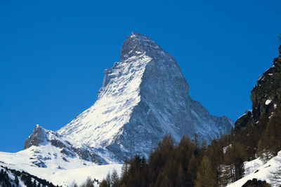 Scenic view of snowcapped mountains against clear blue sky