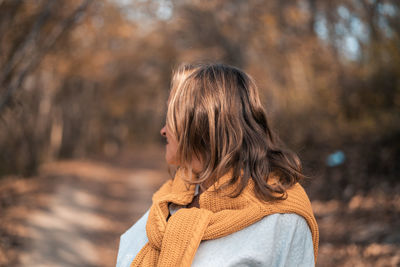 Woman standing by tree during winter