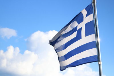 Low angle view of greek flag against blue sky