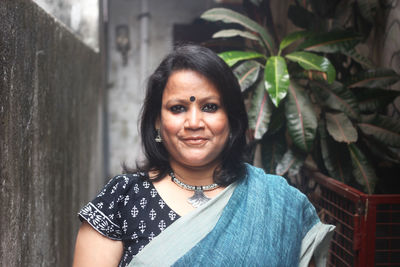 Portrait of mid adult woman wearing sari while standing in alley